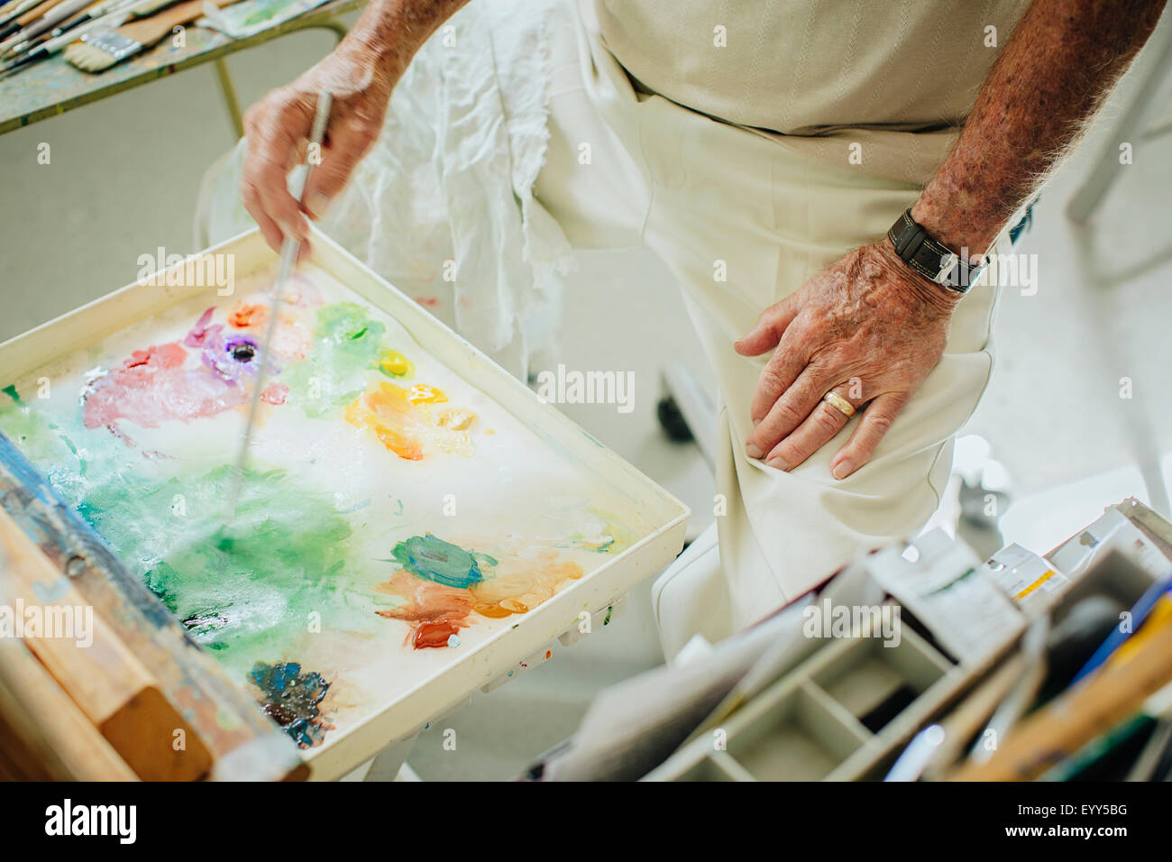 Artista caucasica la miscelazione di vernice nella tavolozza in studio Foto Stock