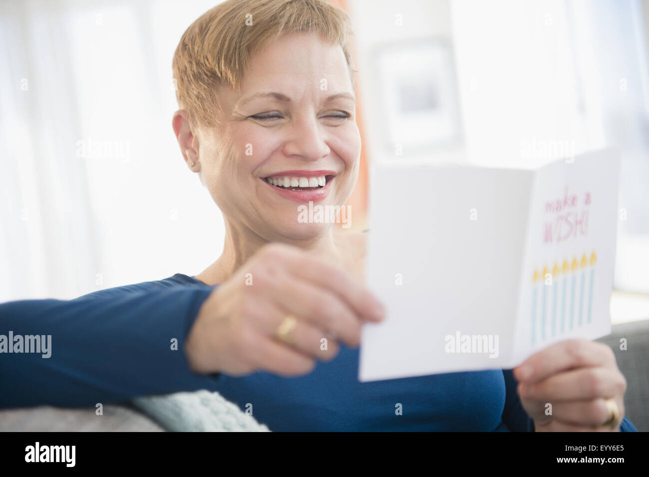 La donna caucasica la lettura di biglietto di auguri di compleanno Foto Stock