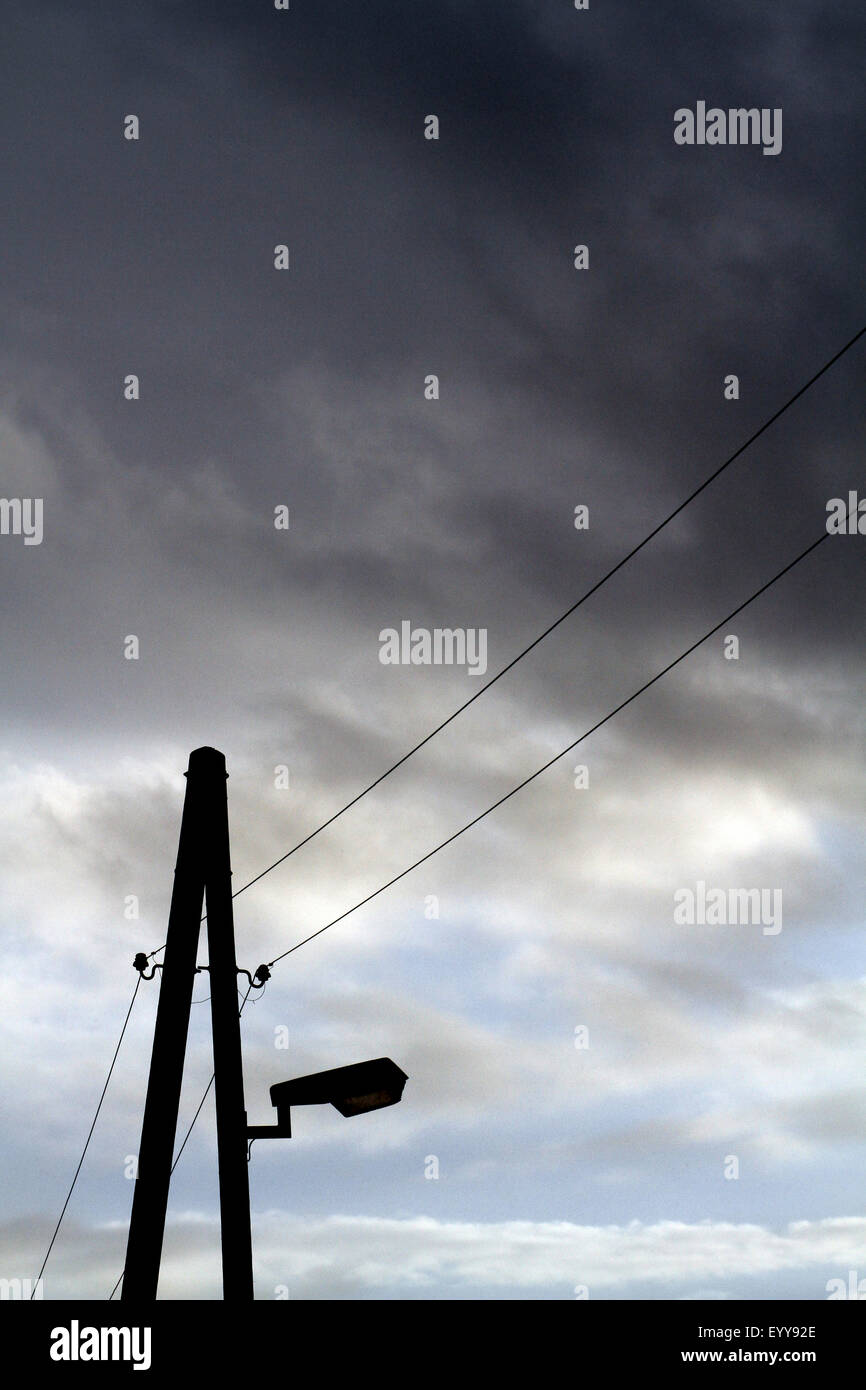 Dark Cloud pioggia al di sopra di illuminazione stradale e linee di alimentazione aeree, Germania Foto Stock