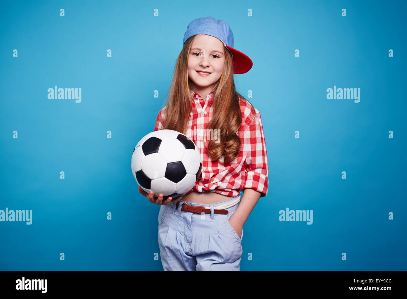 Sorridente ragazza con pallone da calcio e guardando la fotocamera Foto Stock