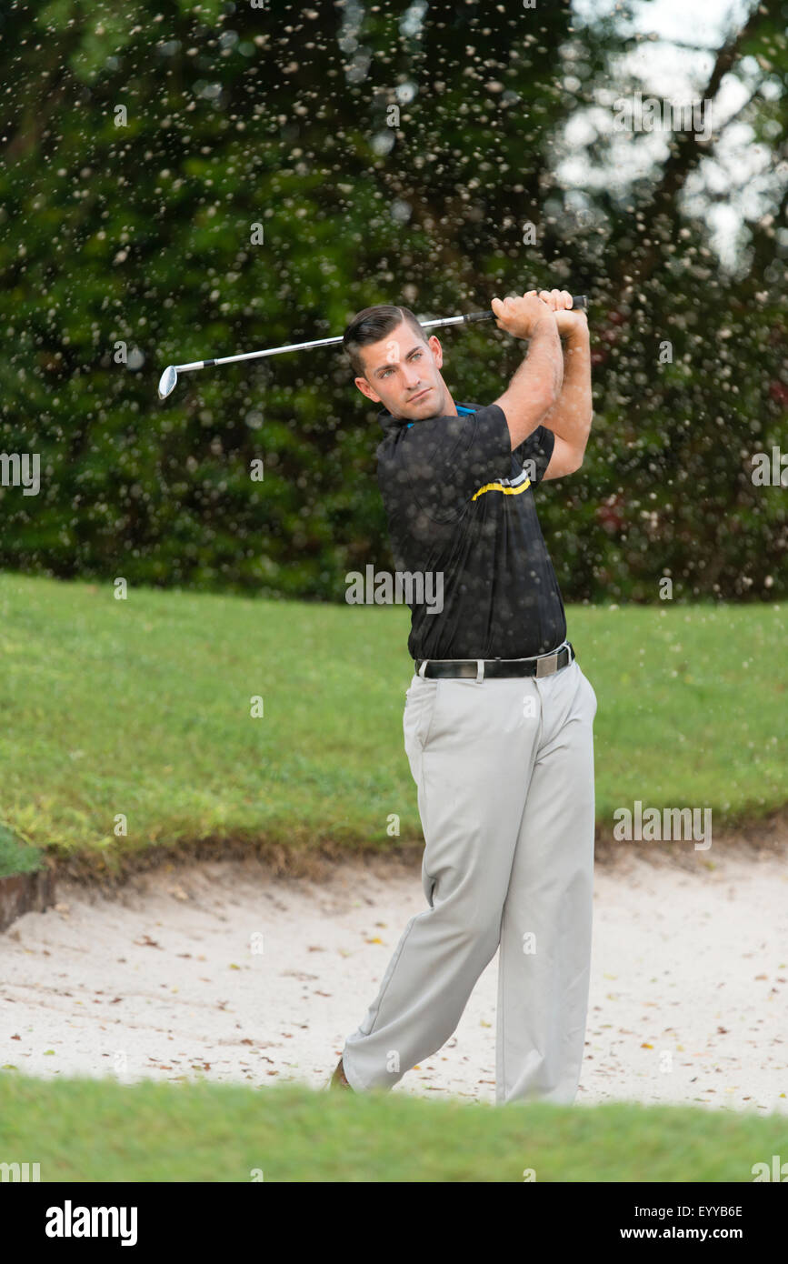 Uomo caucasico scheggiature dal campo da golf di trappola di sabbia Foto Stock