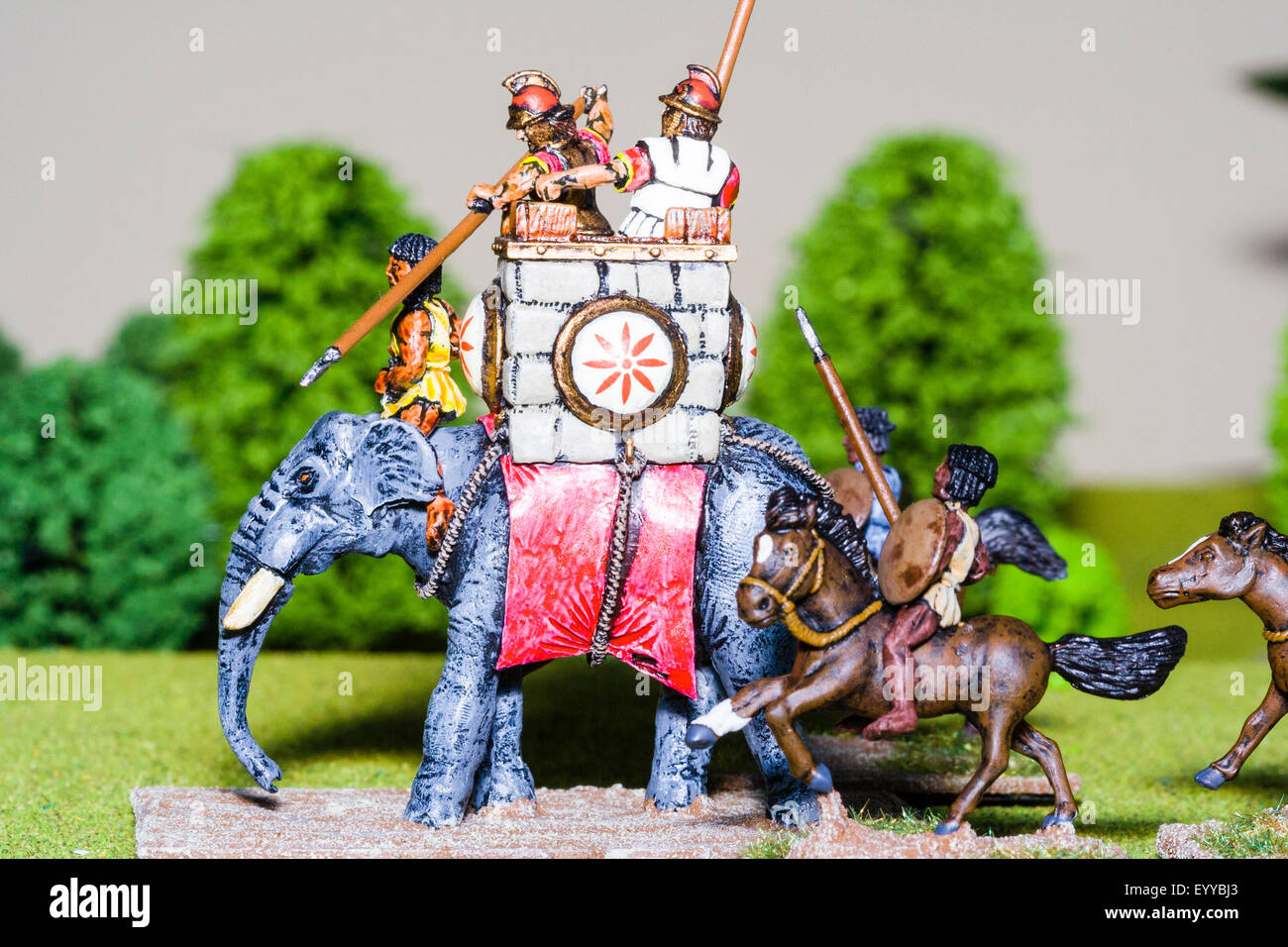 Close-up di metallo verniciato modello figure di una guerra cartaginese elefante con figure di cavalleria impostato sul modello erba come nel tavolo di gioco di guerra. Foto Stock