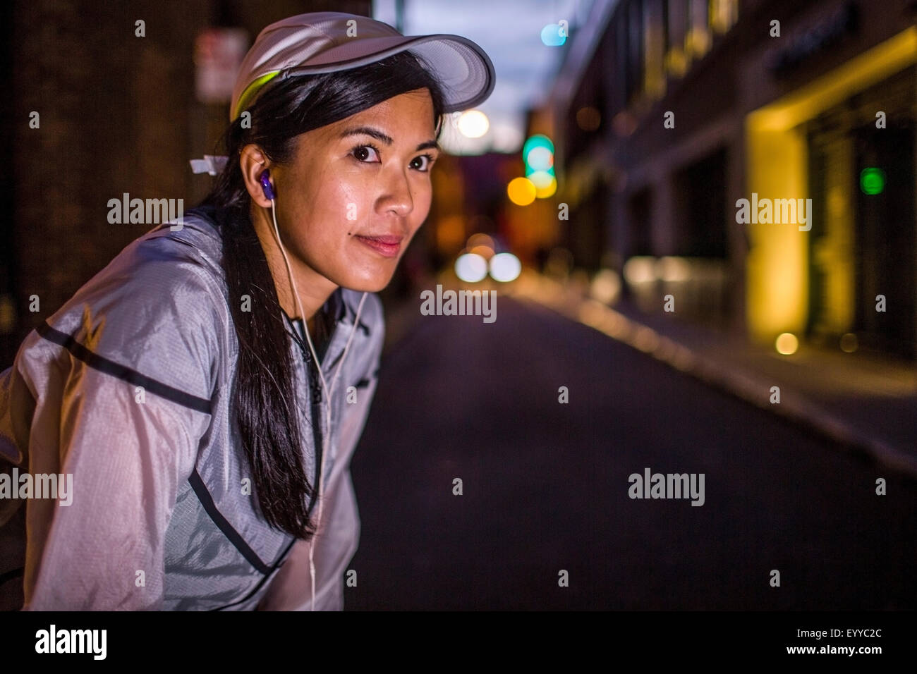 Asian runner in appoggio su una strada di città di notte Foto Stock