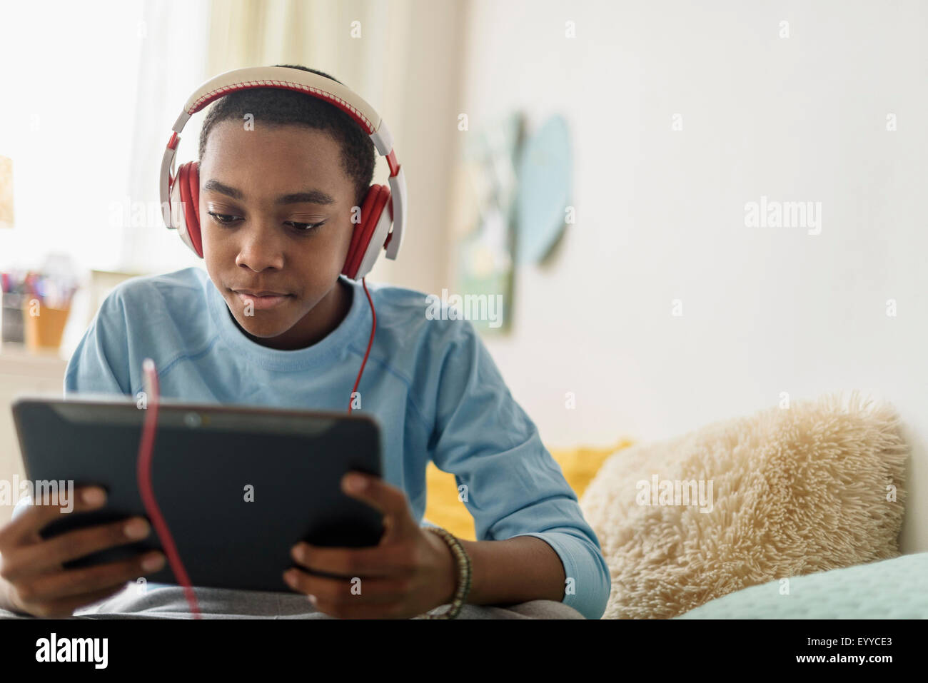 Black Boy in cuffie utilizzando tavoletta digitale Foto Stock