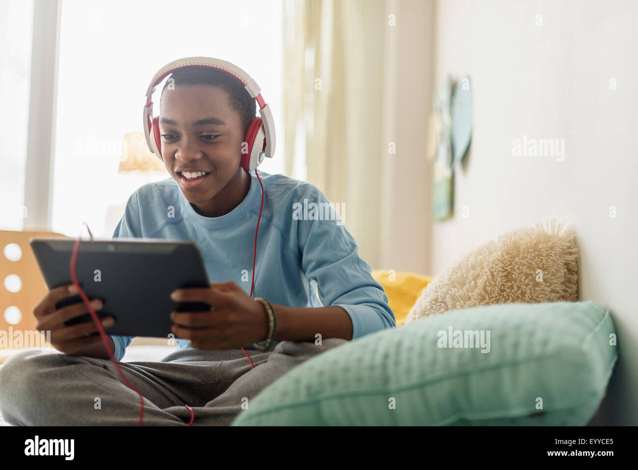 Black Boy in cuffie utilizzando tavoletta digitale Foto Stock
