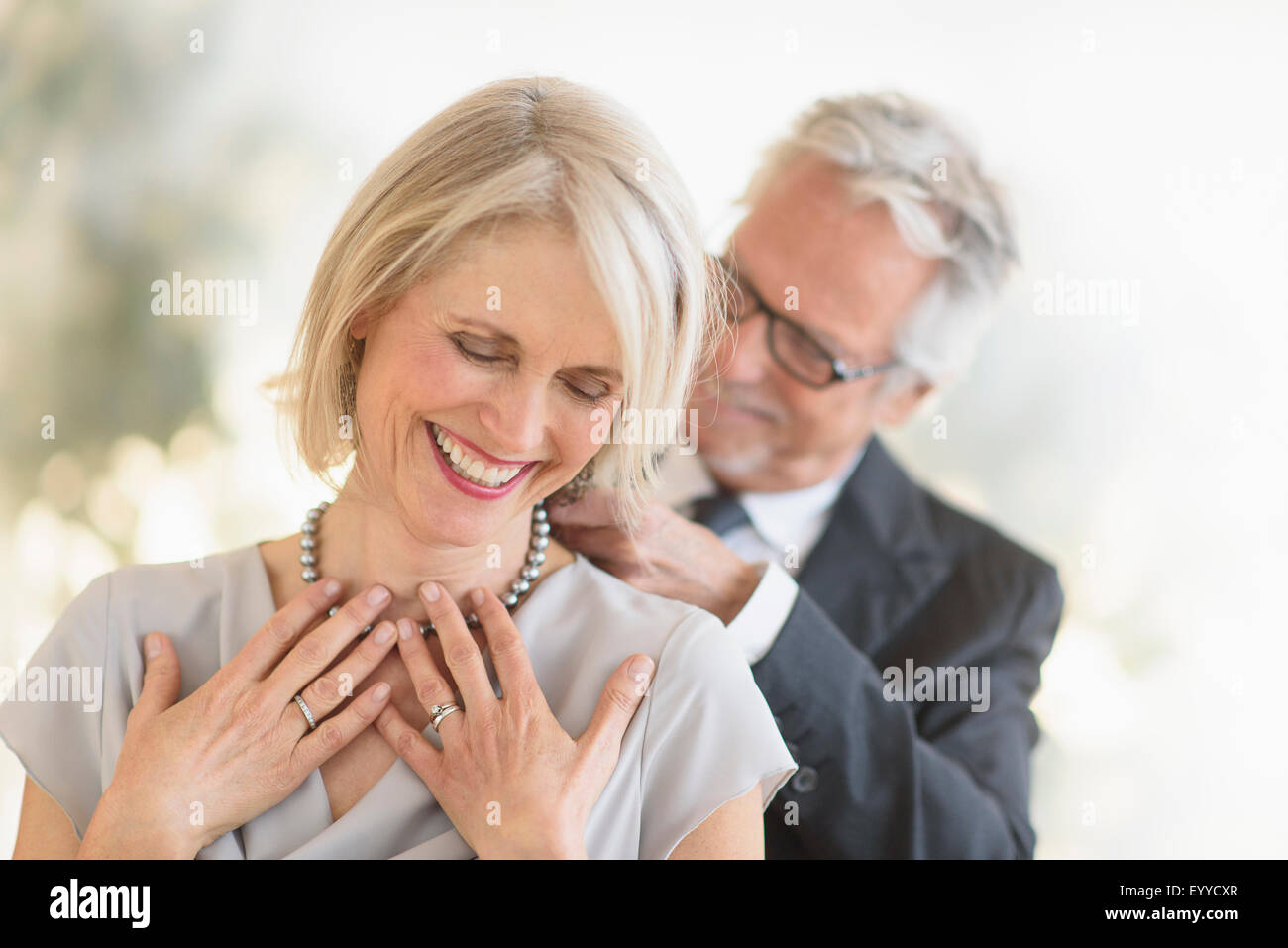 Sorridente vecchio uomo caucasico dando moglie una collana Foto Stock