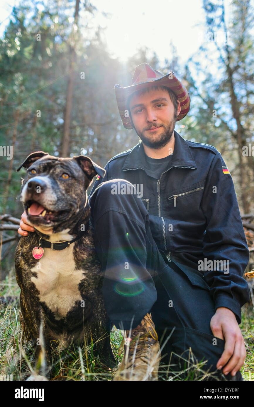 Uomo caucasico udienza con il cane nel campo Foto Stock