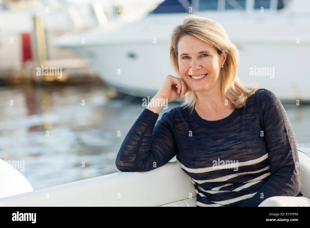 Caucasian donna seduta sulla barca in porto Foto Stock