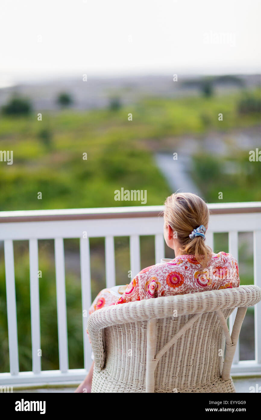 La donna caucasica ammirando vista dalla veranda Foto Stock