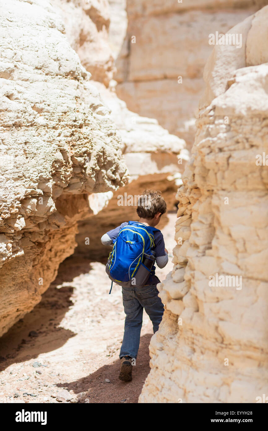 Ragazzo caucasico ad esplorare il deserto formazioni di roccia Foto Stock