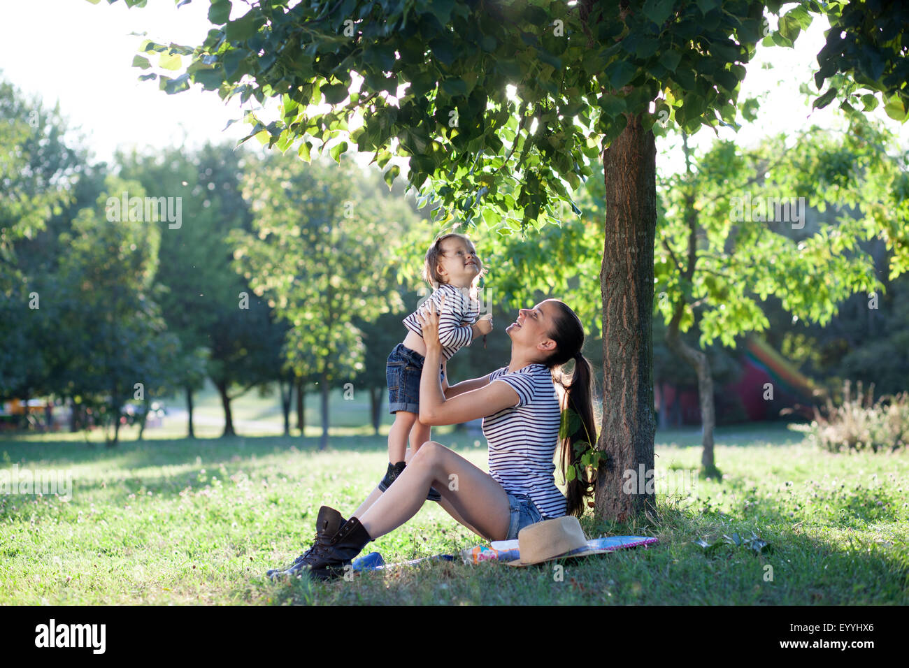 Giovane madre sollevamento bambino sulle mani in aria Foto Stock