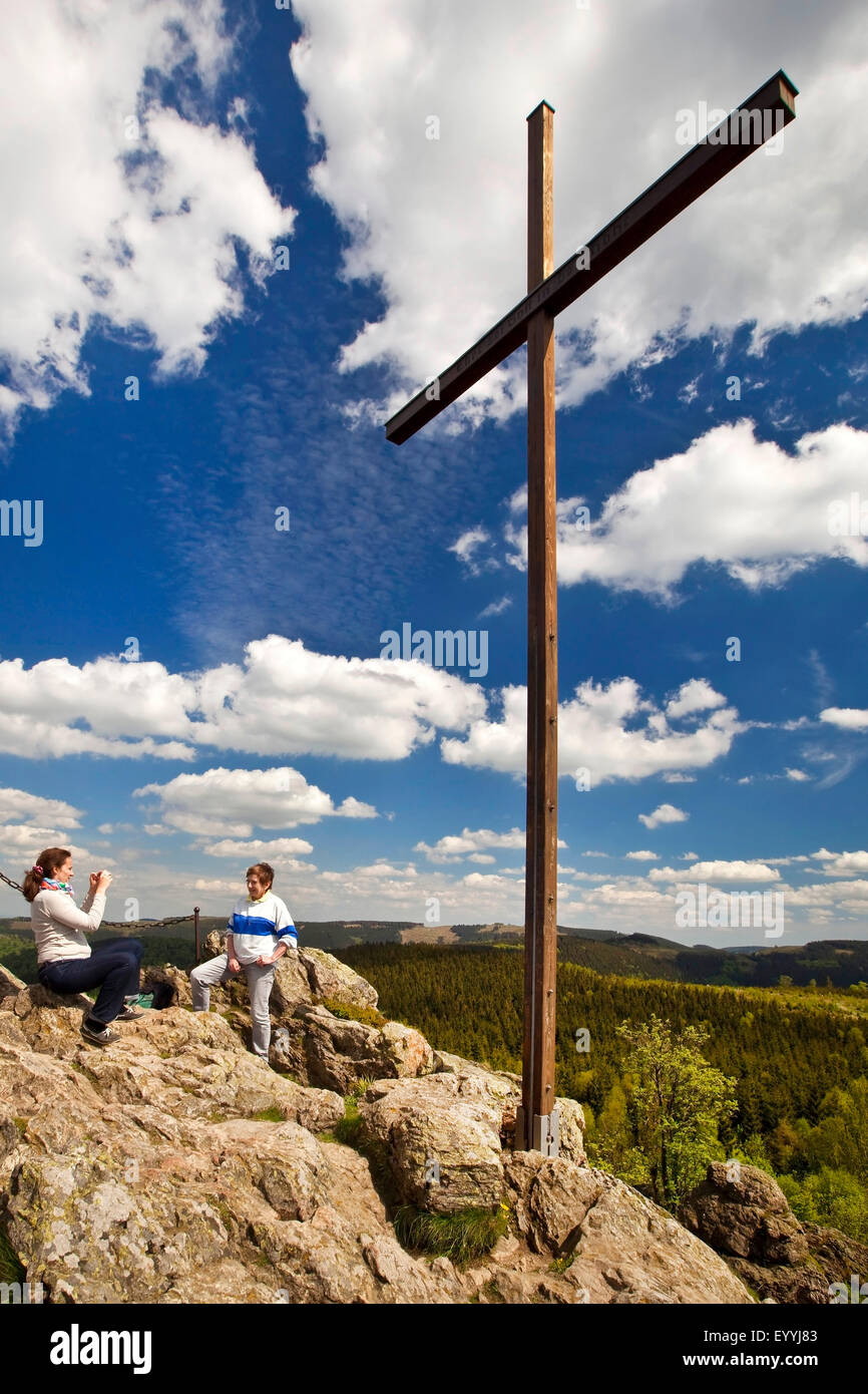 Due donne vicino al vertice di croce sulla formazione di roccia Feldstein, Bruchhauser Steine, in Germania, in Renania settentrionale-Vestfalia, Sauerland, Olsberg Foto Stock