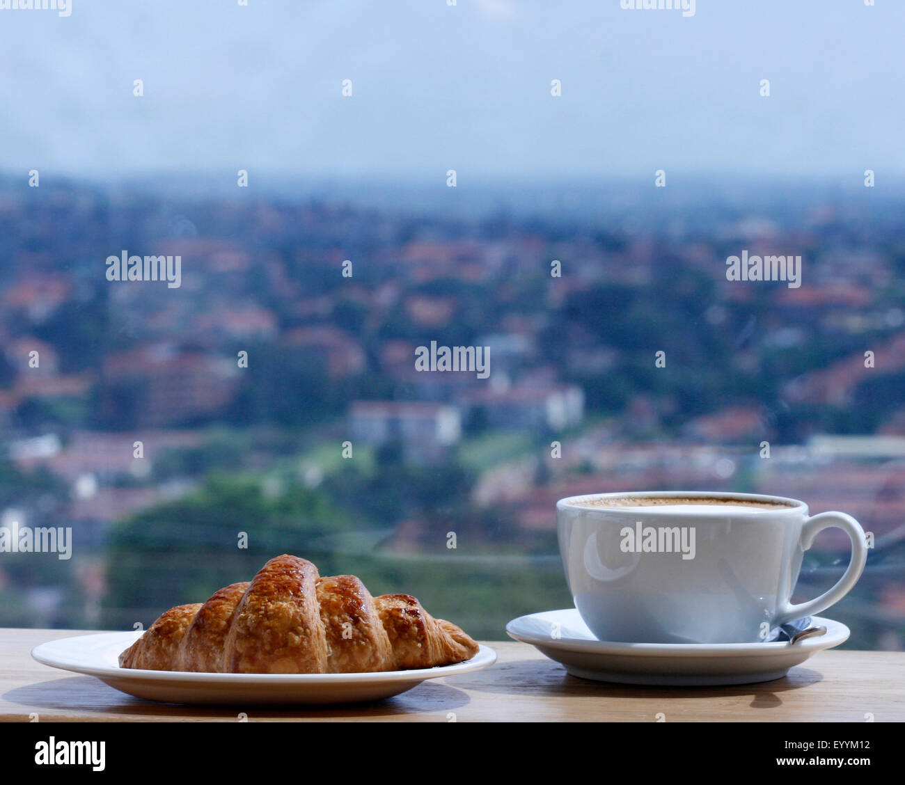 Un cappuccino e un cornetto con una vista Foto Stock