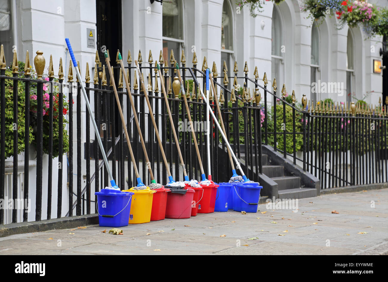 Fornitori di apparecchiature di pulizia schierate al di fuori di una prestigiosa casa georgiana nel centro di Londra. Mostra Spazzoloni e secchi. Foto Stock