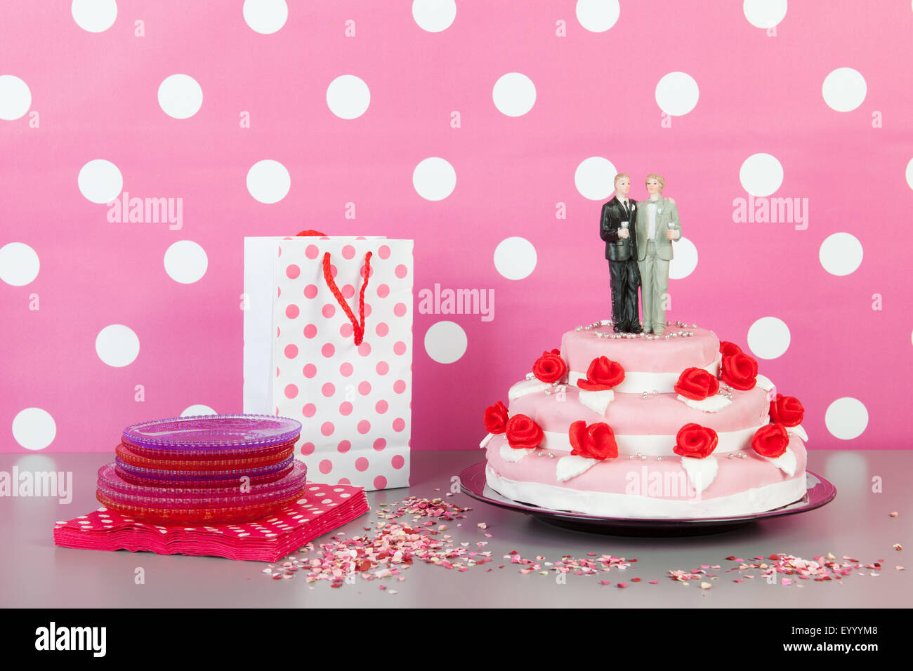 Rosa torta di nozze con rose rosse e coppia gay sulla parte superiore Foto Stock