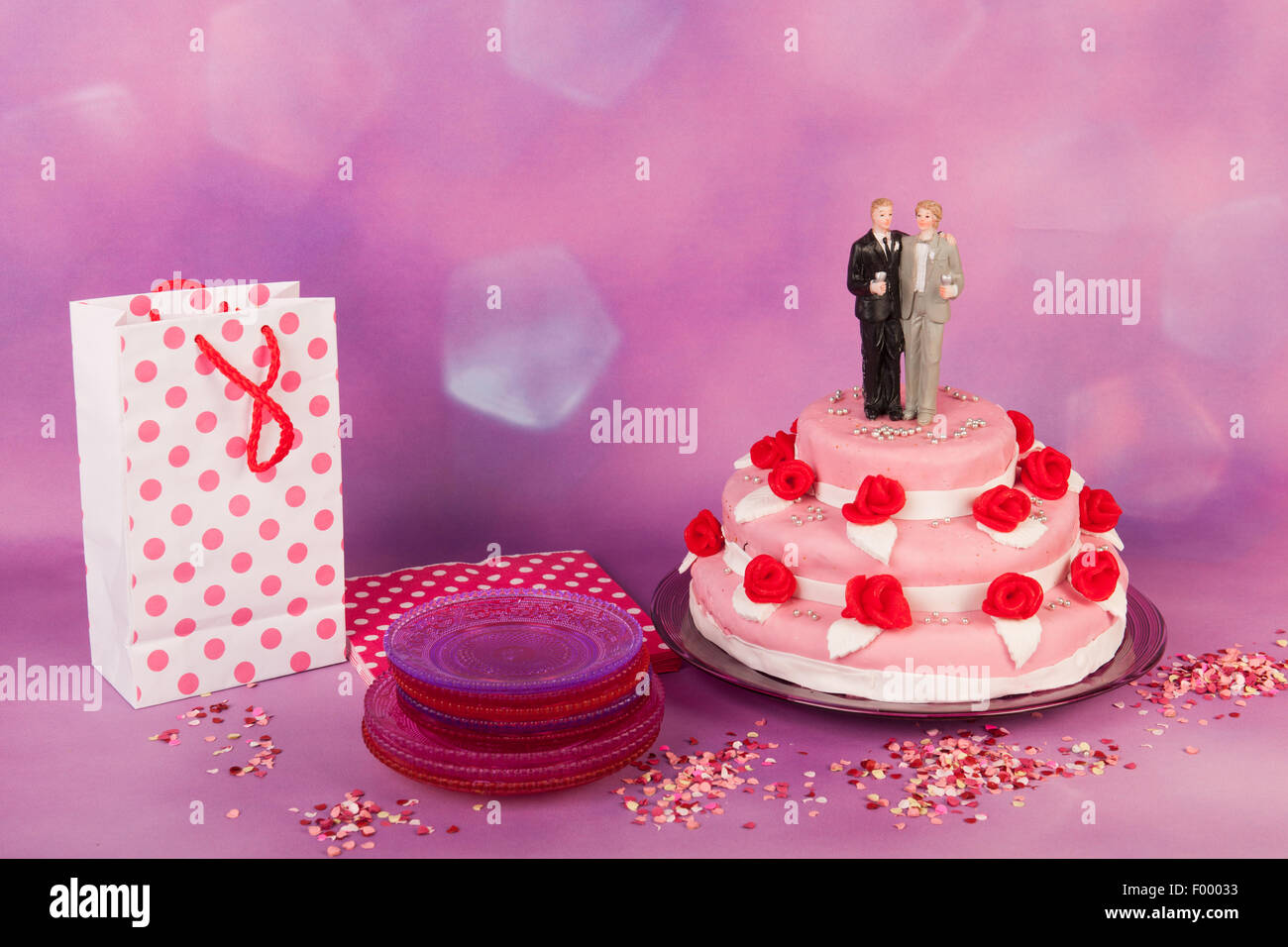 Rosa torta di nozze con rose rosse e coppia gay sulla parte superiore Foto Stock