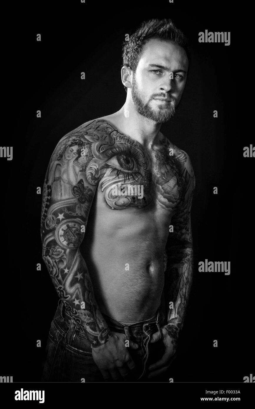 Retro-illuminato maschio corpo tatuato. Foto Stock