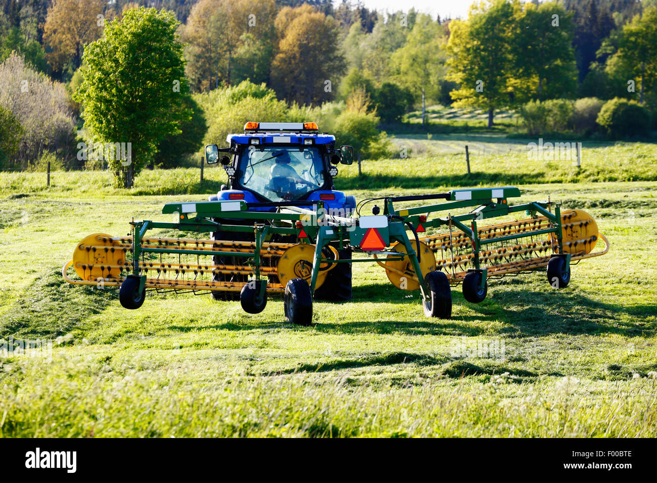 Trattrice agricola arando un campo lussureggiante Foto Stock