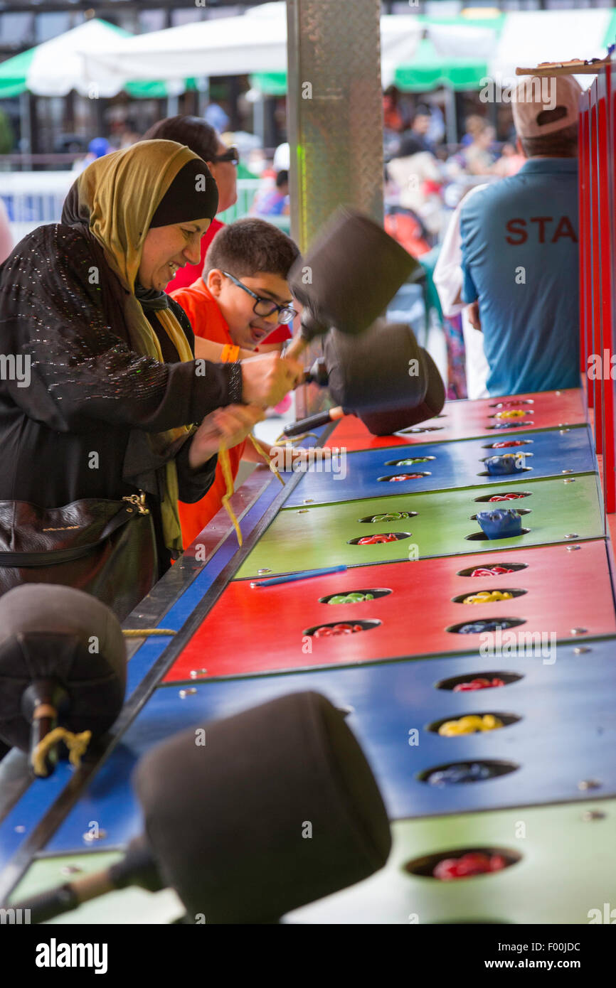 Musulmani madre e figlio giocare "Whac una mole 'gioco, giardini vittoriani, Central Park, New York, Stati Uniti d'America Foto Stock