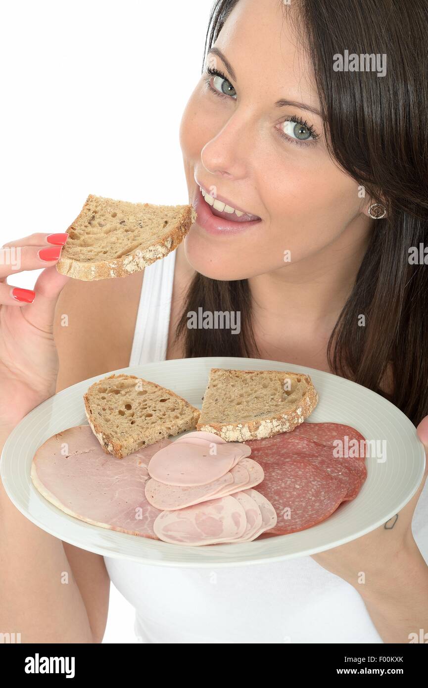 Giovane donna tenendo una piastra di stile Scandinavo colazione con una selezione di salumi e fette di pane isolata contro uno sfondo bianco Foto Stock