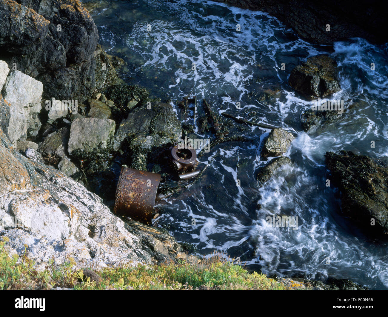 Rottami di metallo che giace sulle rocce sotto sea cliff Ogof Ystwffwl Glas appena SW di Bardsey Island Lighthouse, Gwynedd, il Galles del Nord. Foto Stock