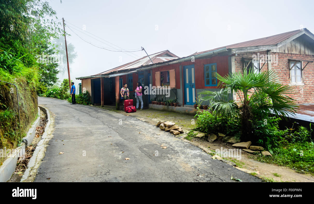 Villaggio montano di strada con casa con i turisti in piedi di fronte con i bagagli e spazio di copia Foto Stock