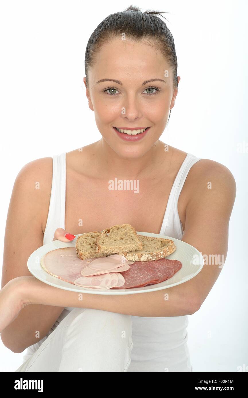 Giovane donna tenendo una piastra di stile Scandinavo colazione con una selezione di salumi e fette di pane isolata contro uno sfondo bianco Foto Stock