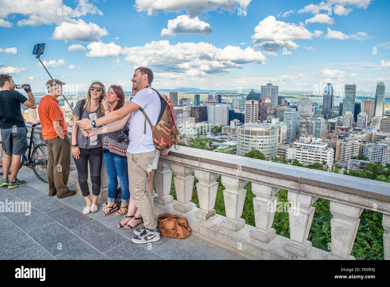 I turisti utilizzando una bacchetta selfie nella parte anteriore della Skyline di Montreal, Kondiaronk belvedere. Foto Stock