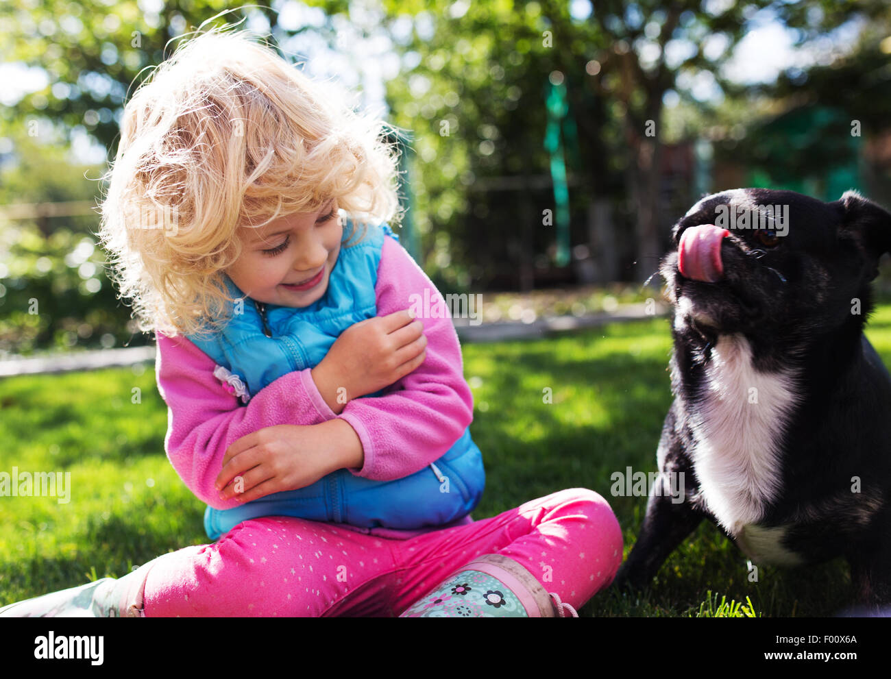 Ritratto di carino bionda bambina giocare all'aperto Foto Stock