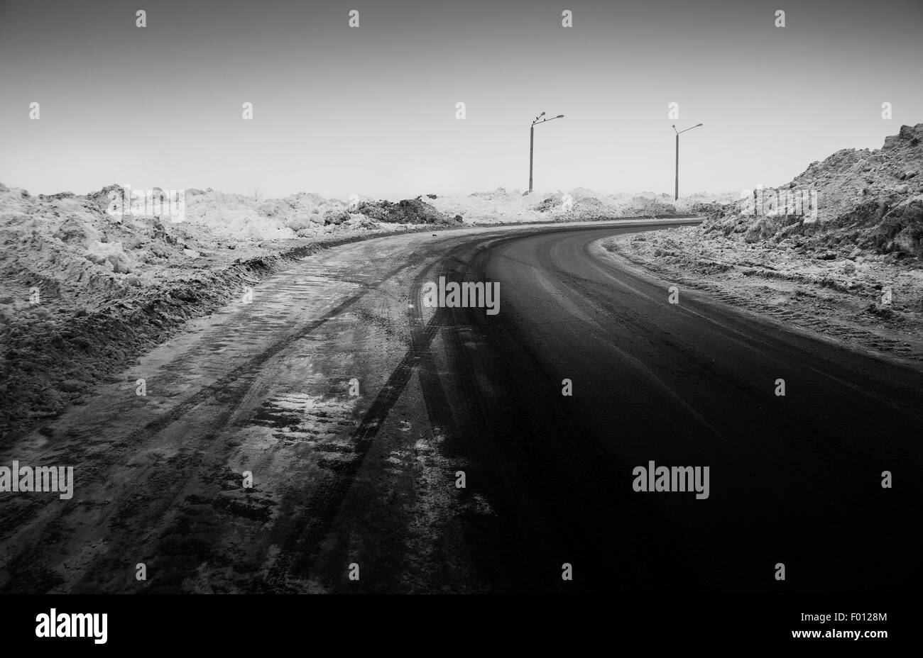 Coperte di neve su strada, i segni delle ruote, foto in bianco e nero Foto Stock