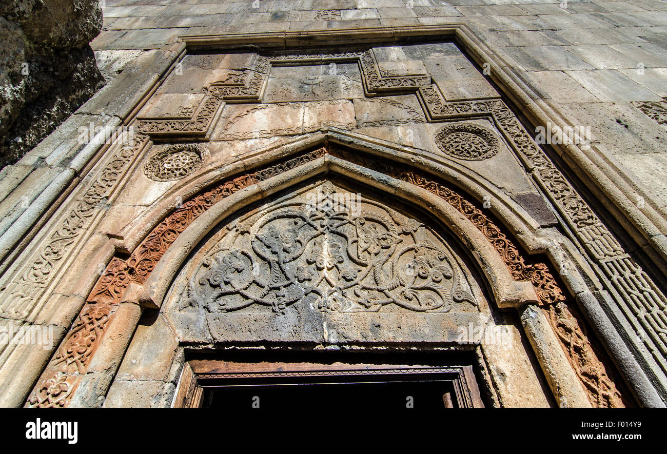 Ingresso ornato di uno storico edificio in pietra che mostra intricate incisioni e tessuti d'invecchiamento Foto Stock