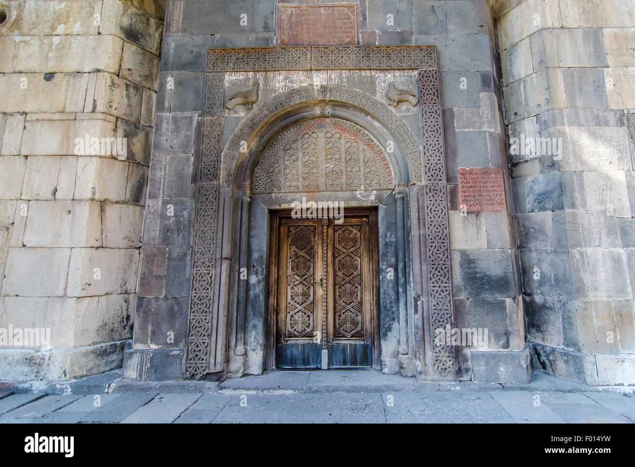 Ingresso ornato di uno storico edificio in pietra che mostra intricate incisioni e tessuti d'invecchiamento Foto Stock