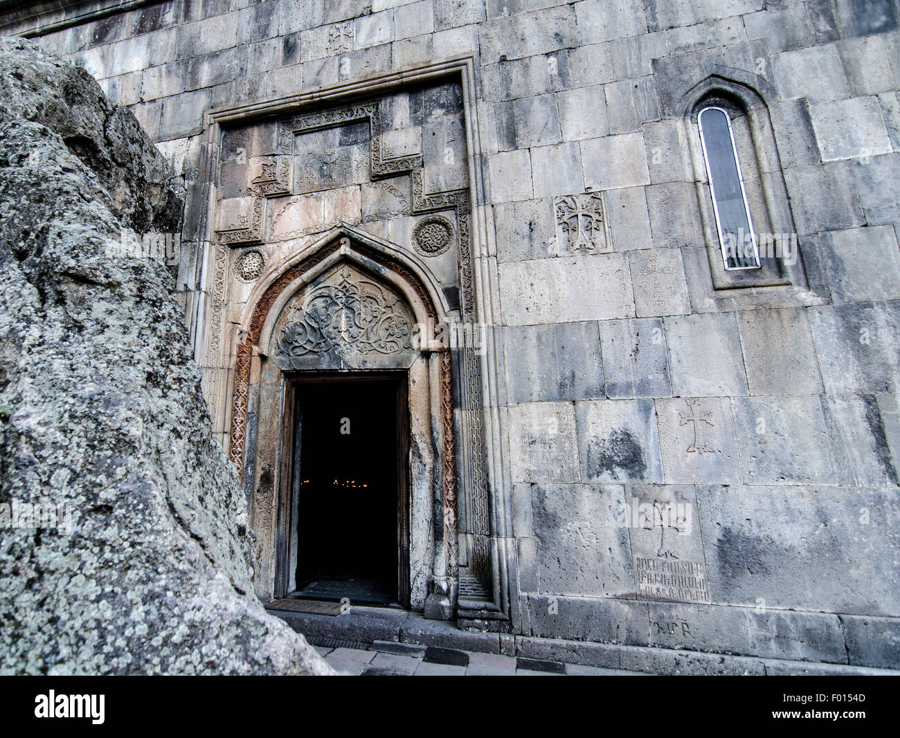 Ingresso ornato di uno storico edificio in pietra che mostra intricate incisioni e tessuti d'invecchiamento Foto Stock