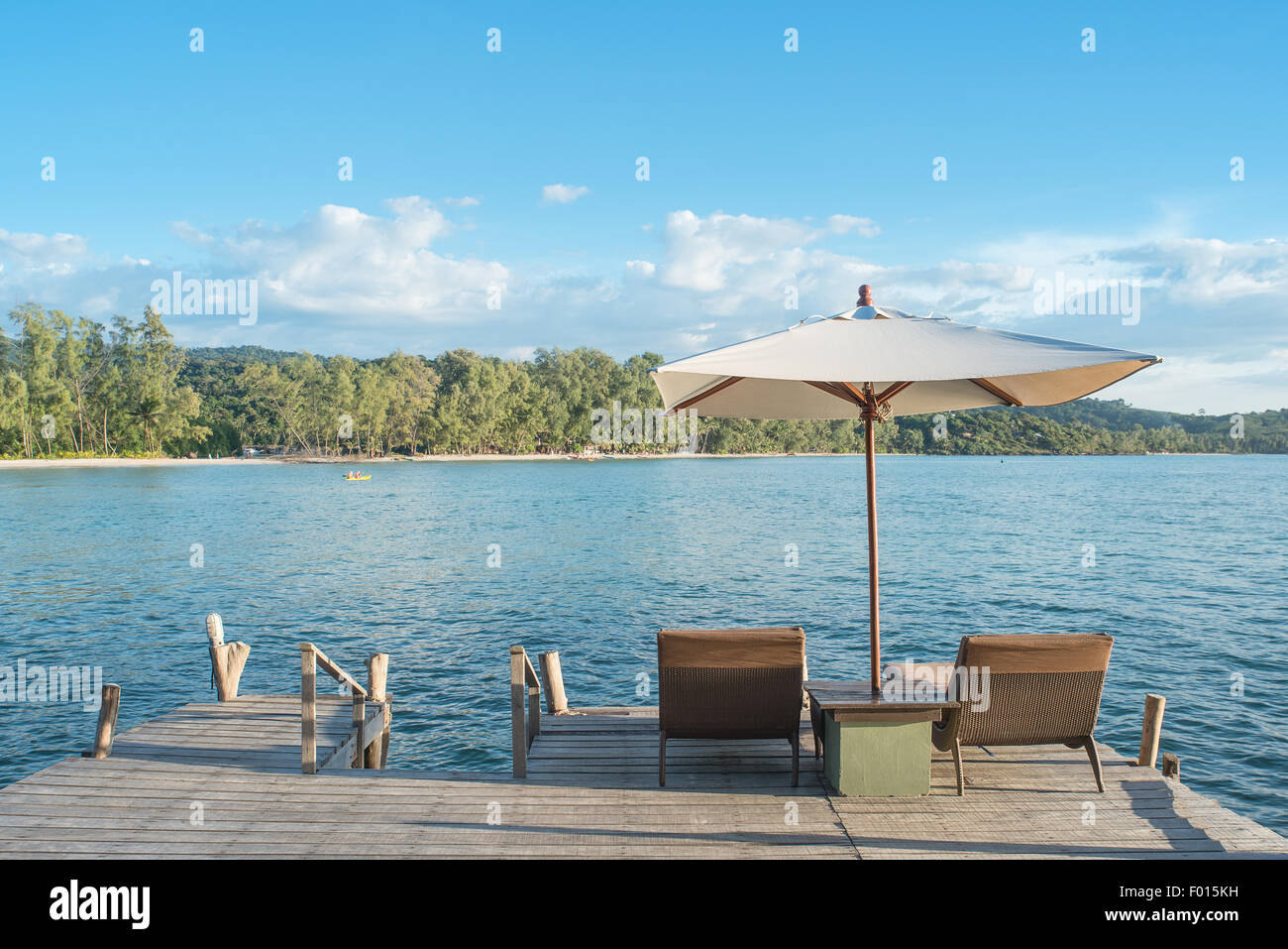 Estate, Viaggi, vacanze e concetto di vacanza - sedie a sdraio e ombrellone sulla scrivania di legno contro il cielo blu in Phuket, Tailandia Foto Stock