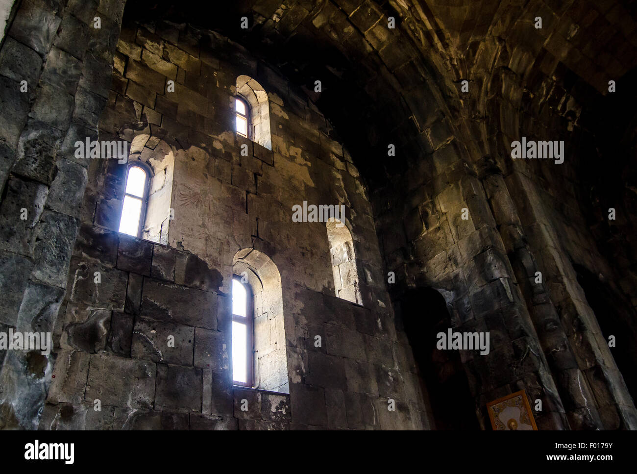 La bellezza architettonica di un antico monastero che presenta intricati lavori in pietra ed elegante lampadario Foto Stock