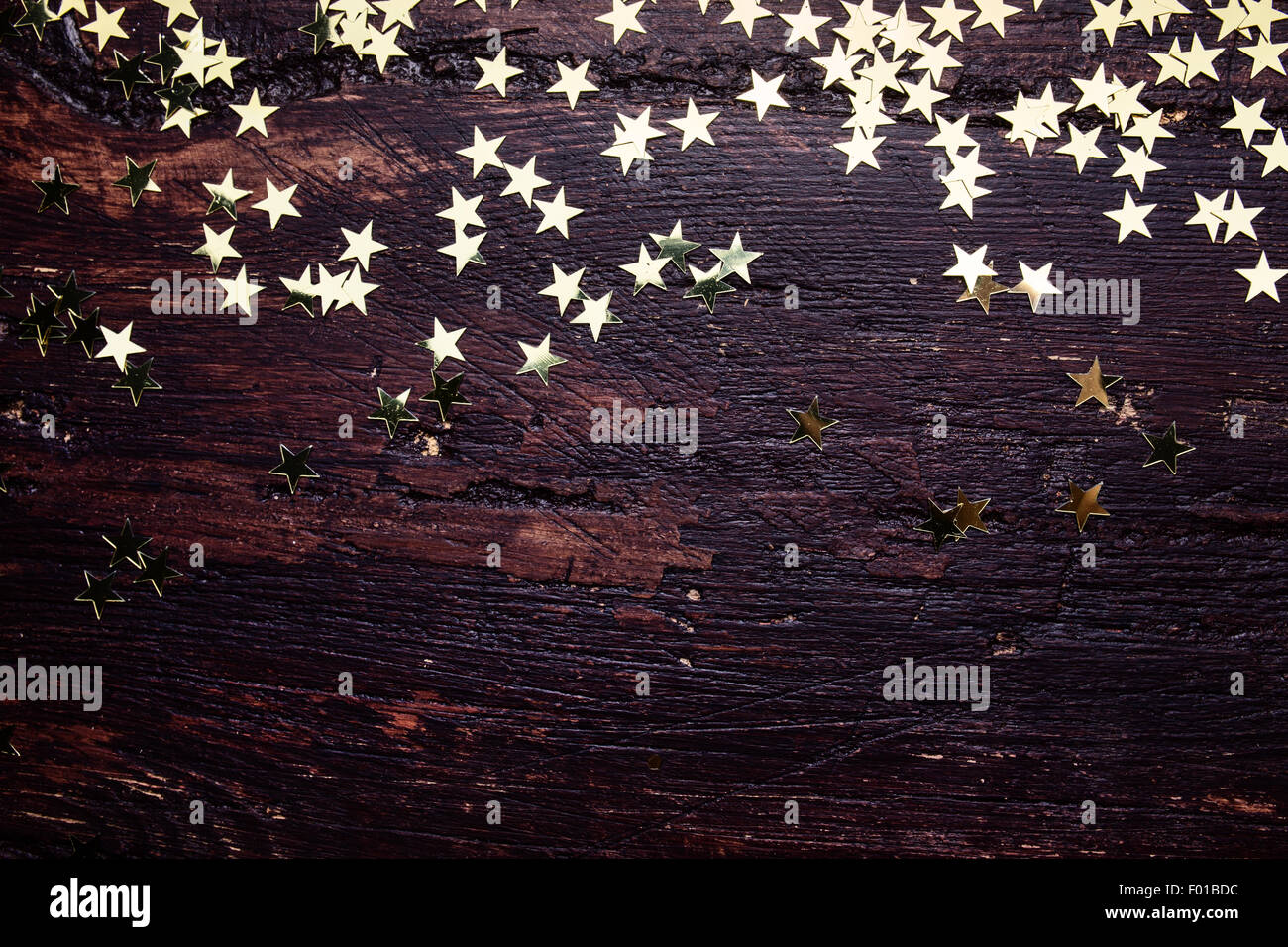 Glitter stelle dorate su grunge Sfondo legno. Sfondo di vacanza Foto Stock