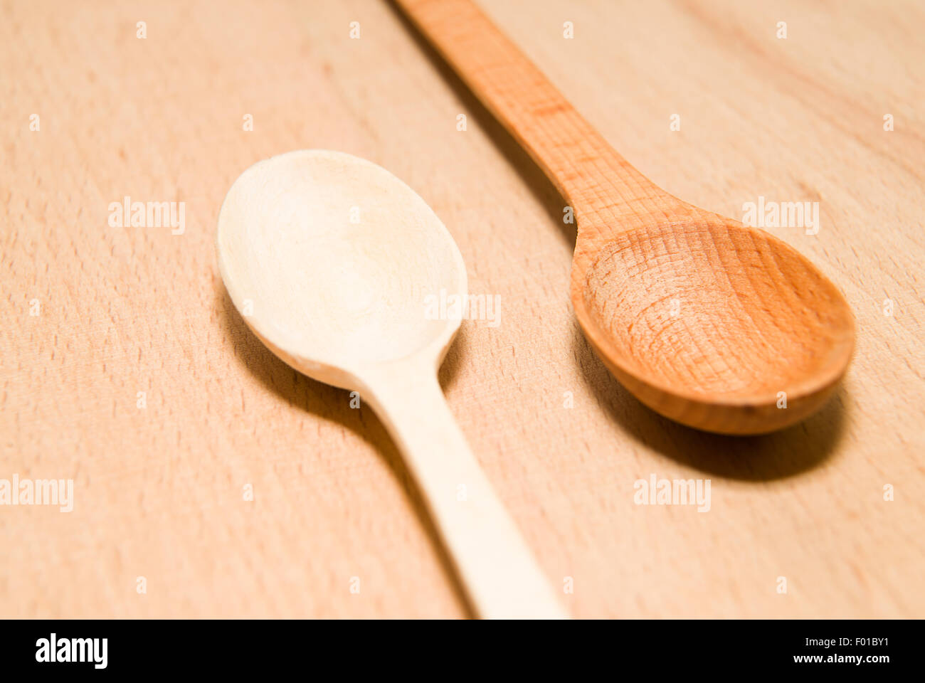 Due cucchiai di legno di diversi colori sono sulla superficie Foto Stock