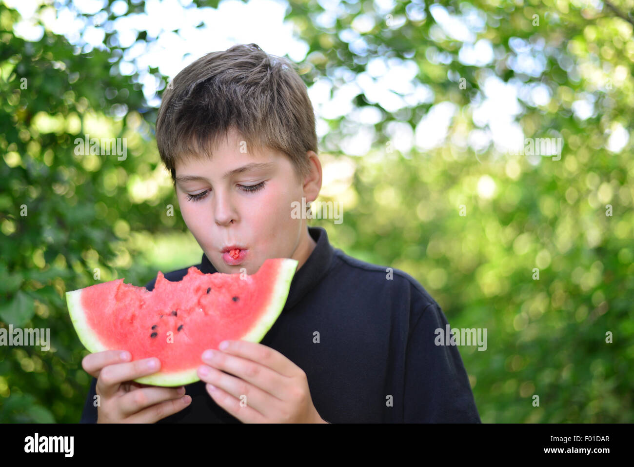 Teen boy mangiando anguria in una natura Foto Stock