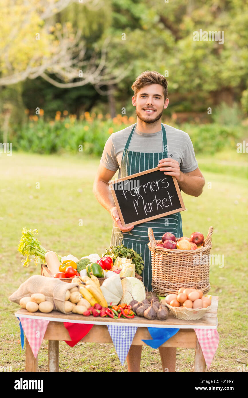 Bello il contadino permanente al suo regime di stallo e di azienda lavagna Foto Stock