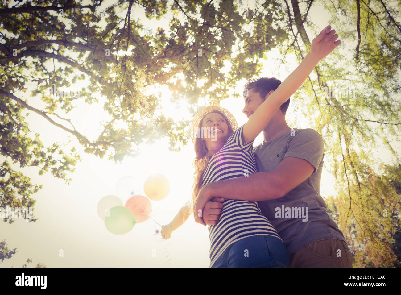 Carino coppia abbracciando e palloncini di contenimento nel parco Foto Stock