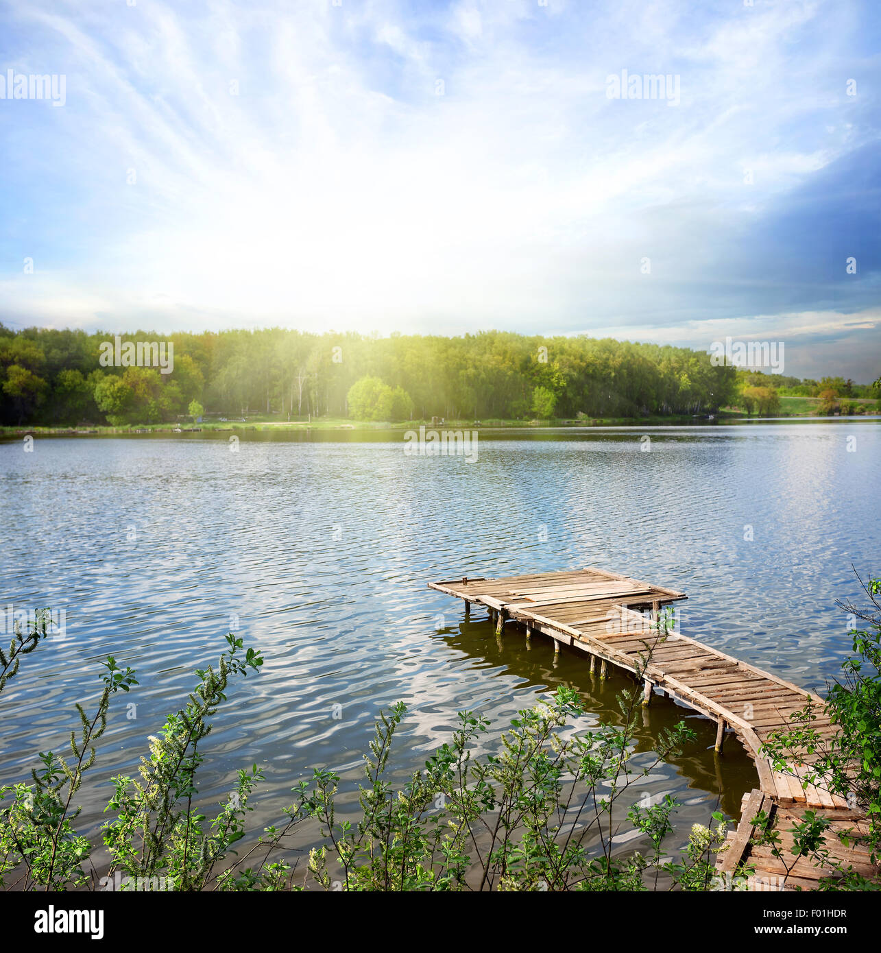 Il molo di legno sul lago sotto cieli soleggiati Foto Stock