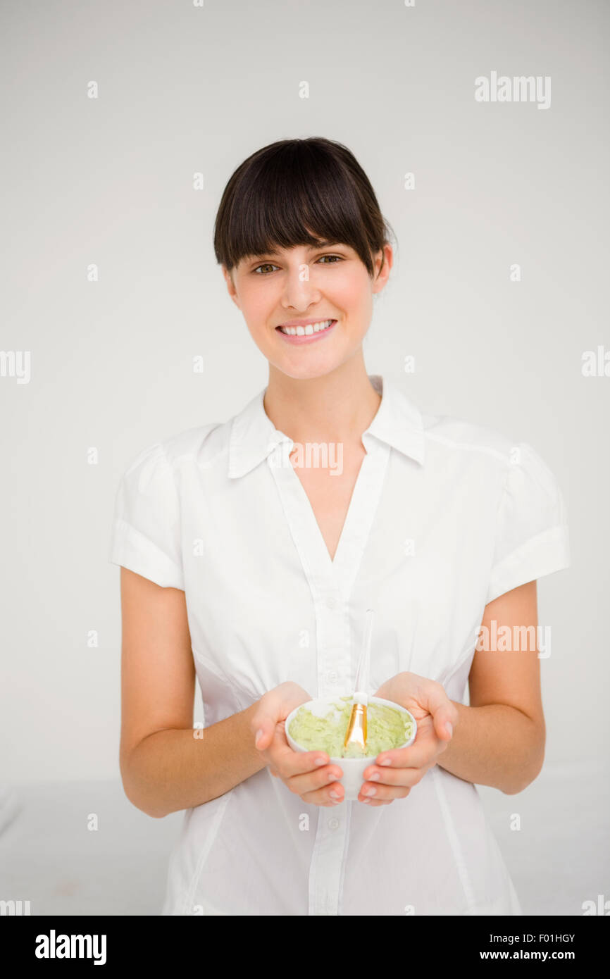 Giovane e bella bruna donna con crema verde per fare un massaggio Foto Stock