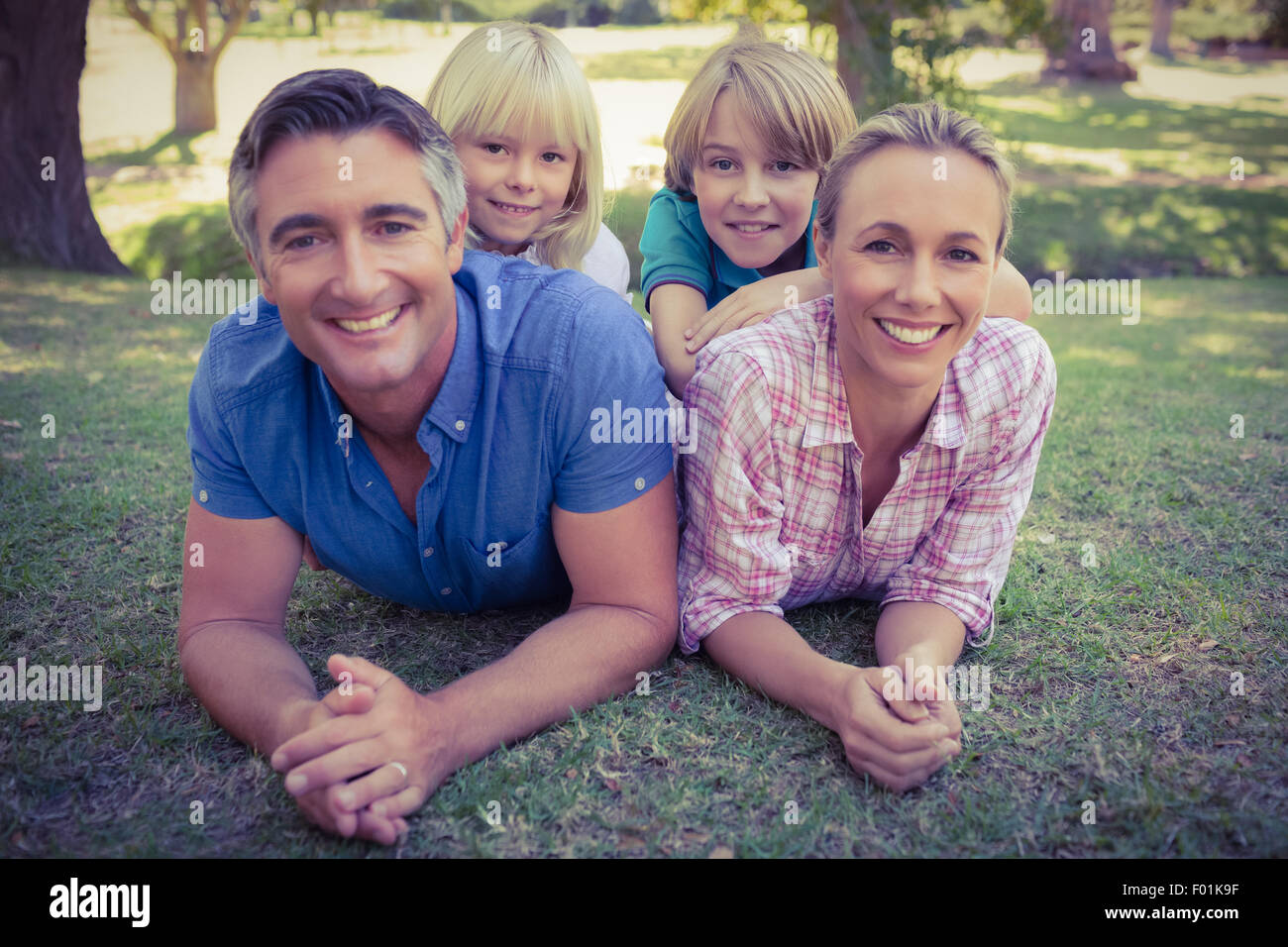 La famiglia felice sorridente verso la telecamera Foto Stock