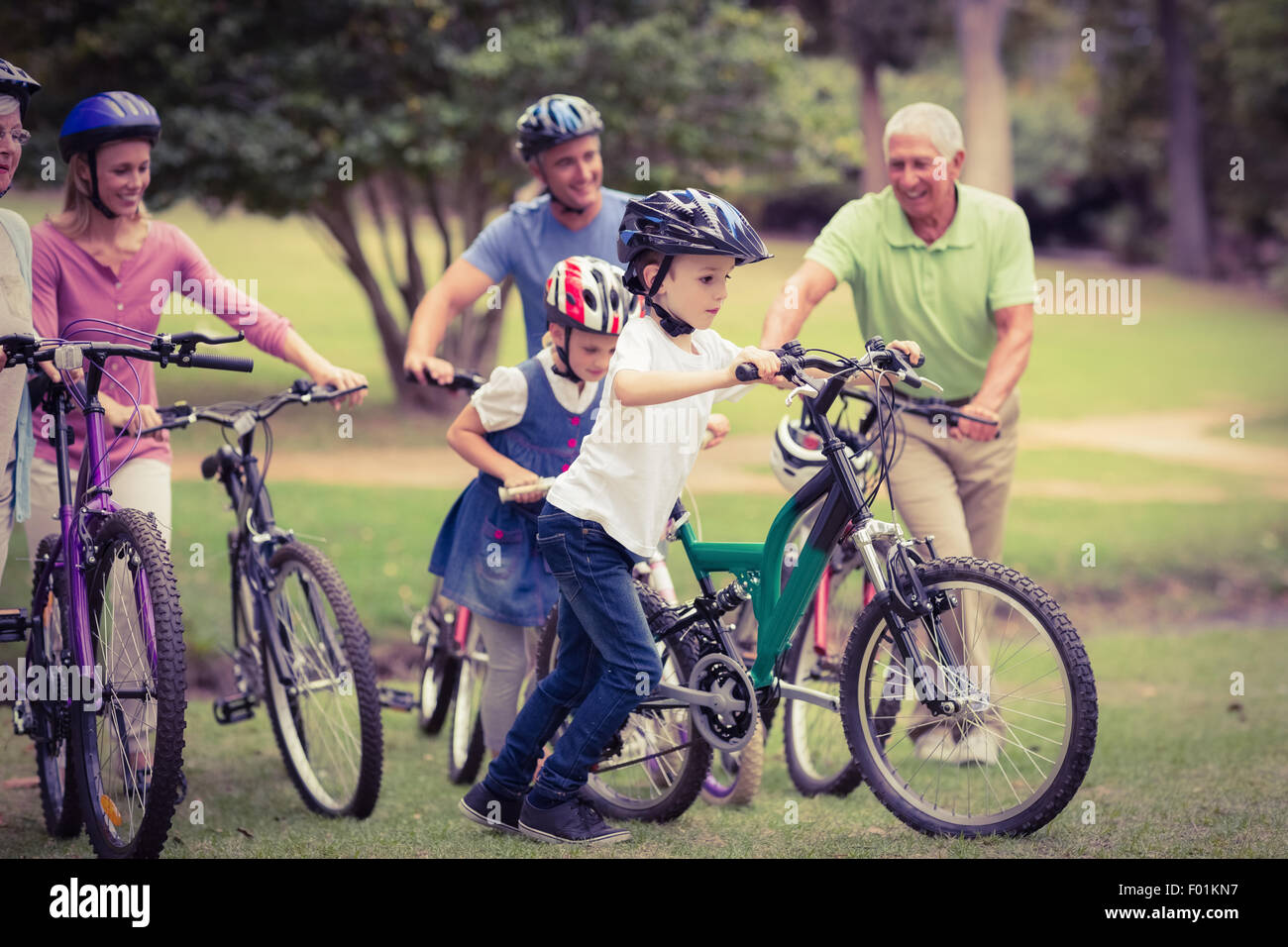 La famiglia felice in bicicletta nel parco Foto Stock