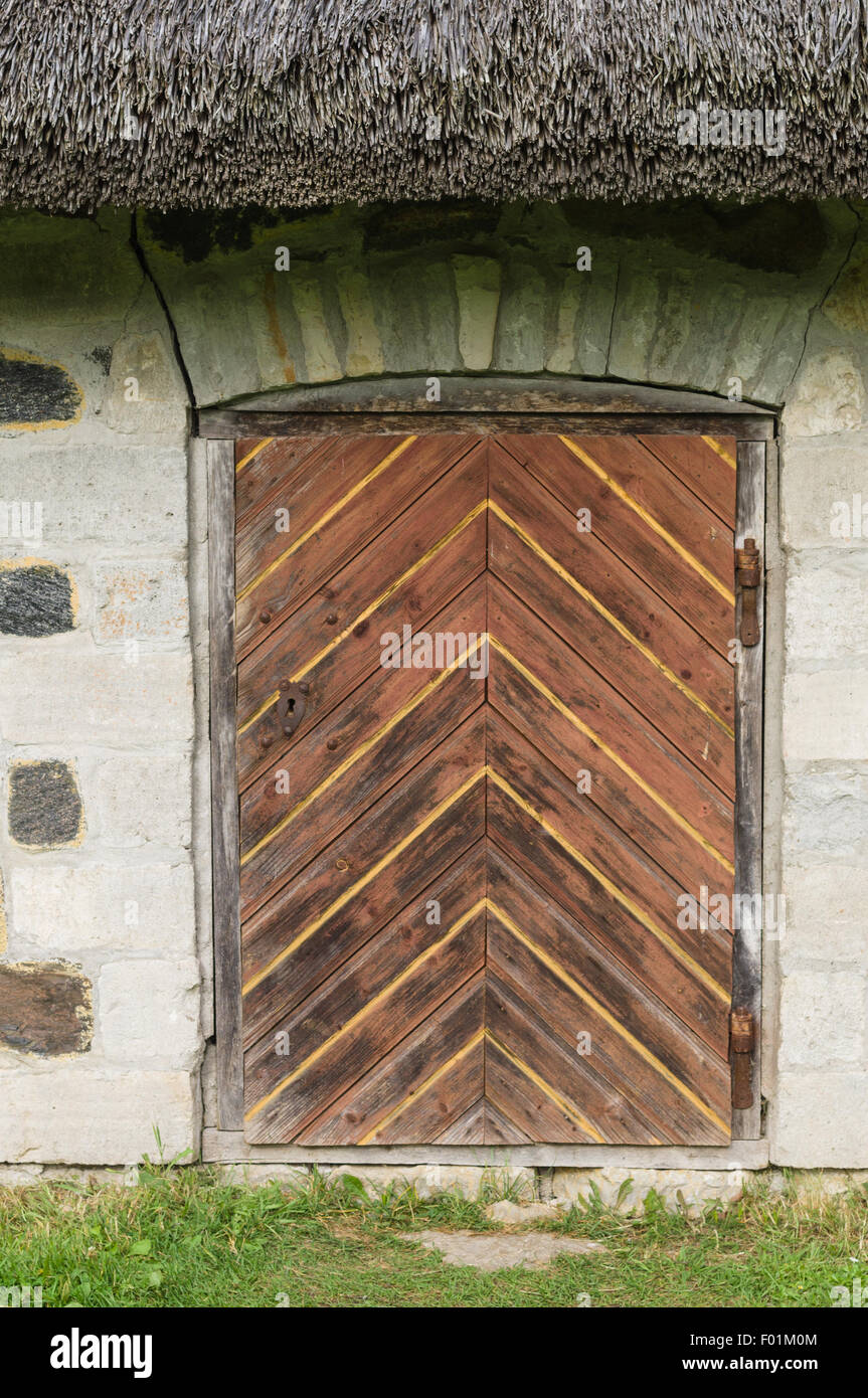 Decorativi antica porta di legno nel vecchio muro di pietra Foto Stock