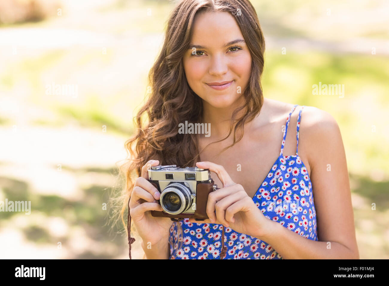 Bella bruna nel parco con fotocamera retrò Foto Stock