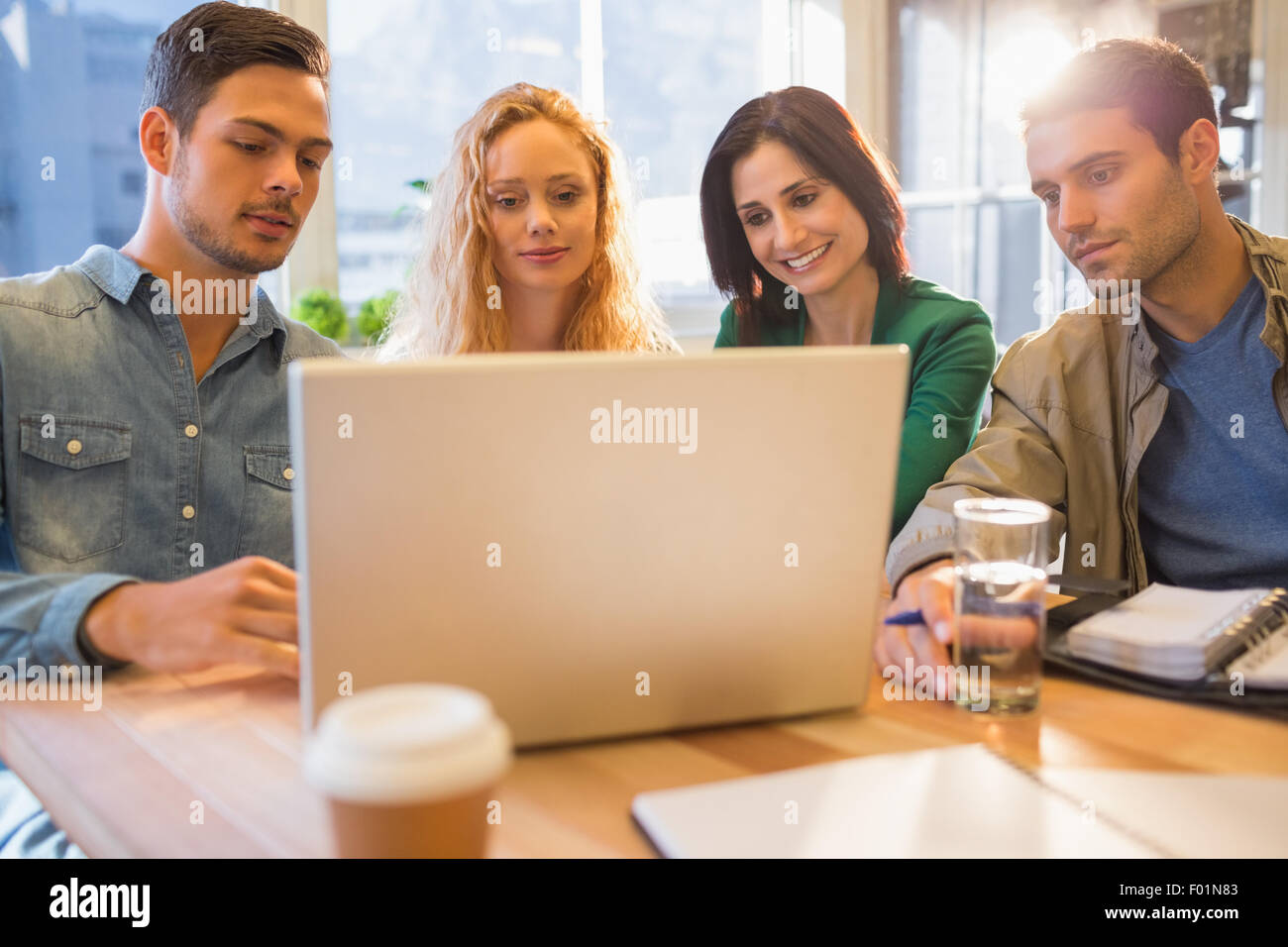 Un gruppo di giovani colleghi utilizzando laptop Foto Stock
