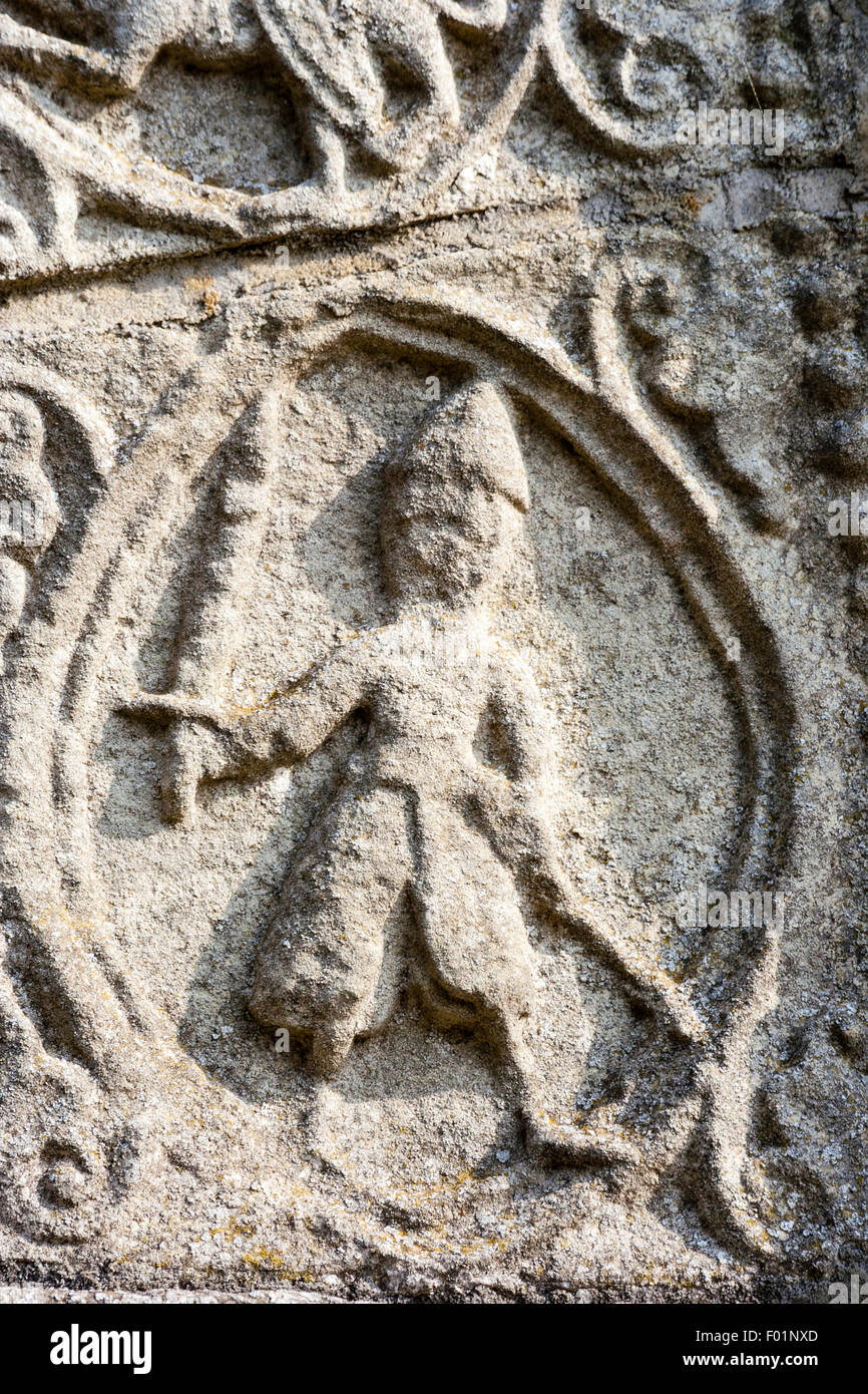 Inghilterra, Barfrestone chiesa. Norman sculture in pietra. Porta sud del timpano, 'Daily rounds " su un Manor House station wagon, uomo d'armi, il cavaliere con la spada. Foto Stock