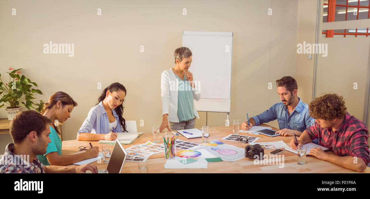 Casual imprenditrice dando presentazione ai suoi colleghi Foto Stock