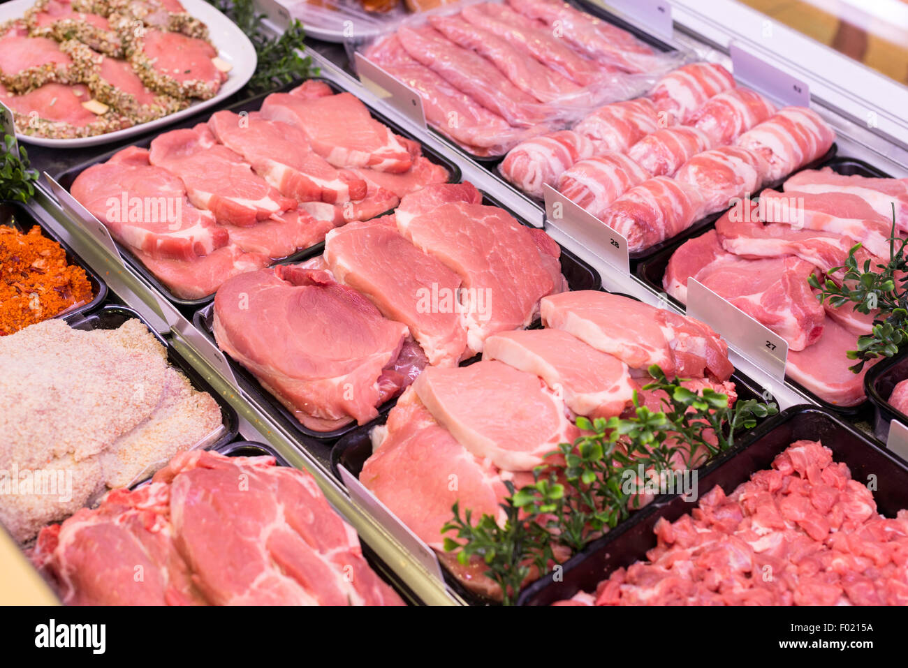 Carni fresche quali prosciutto pancetta salsicce e altri in macelleria Foto Stock